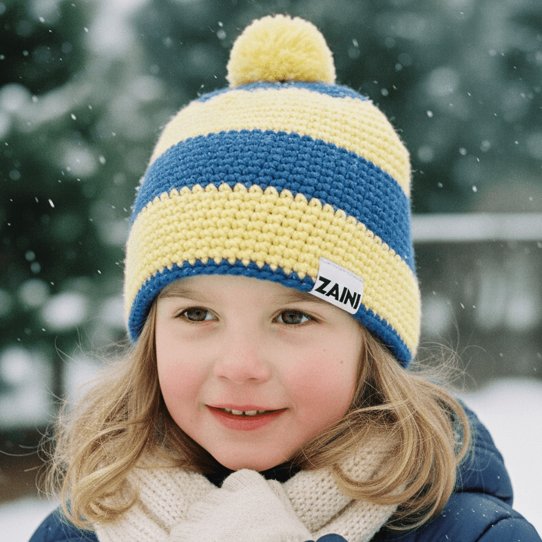 Child wearing a blue and yellow striped knit hat with a pom-pom, standing in a snowy landscape.