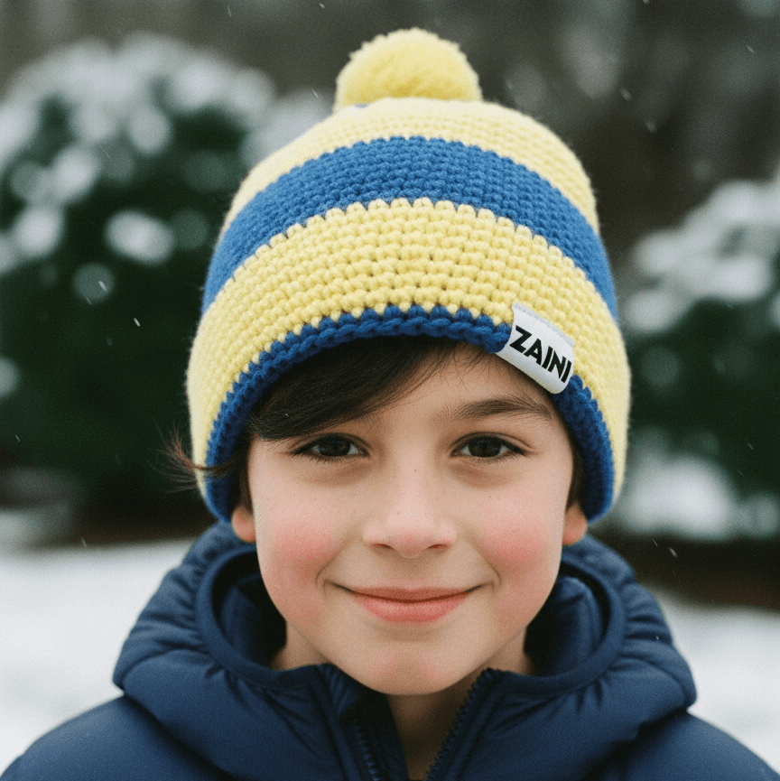Child wearing a blue and yellow striped knit hat with a Zaini tag, standing outdoors in snow.
