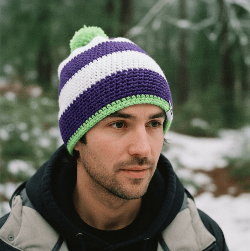 Man wearing a striped knit hat in a snowy forest setting