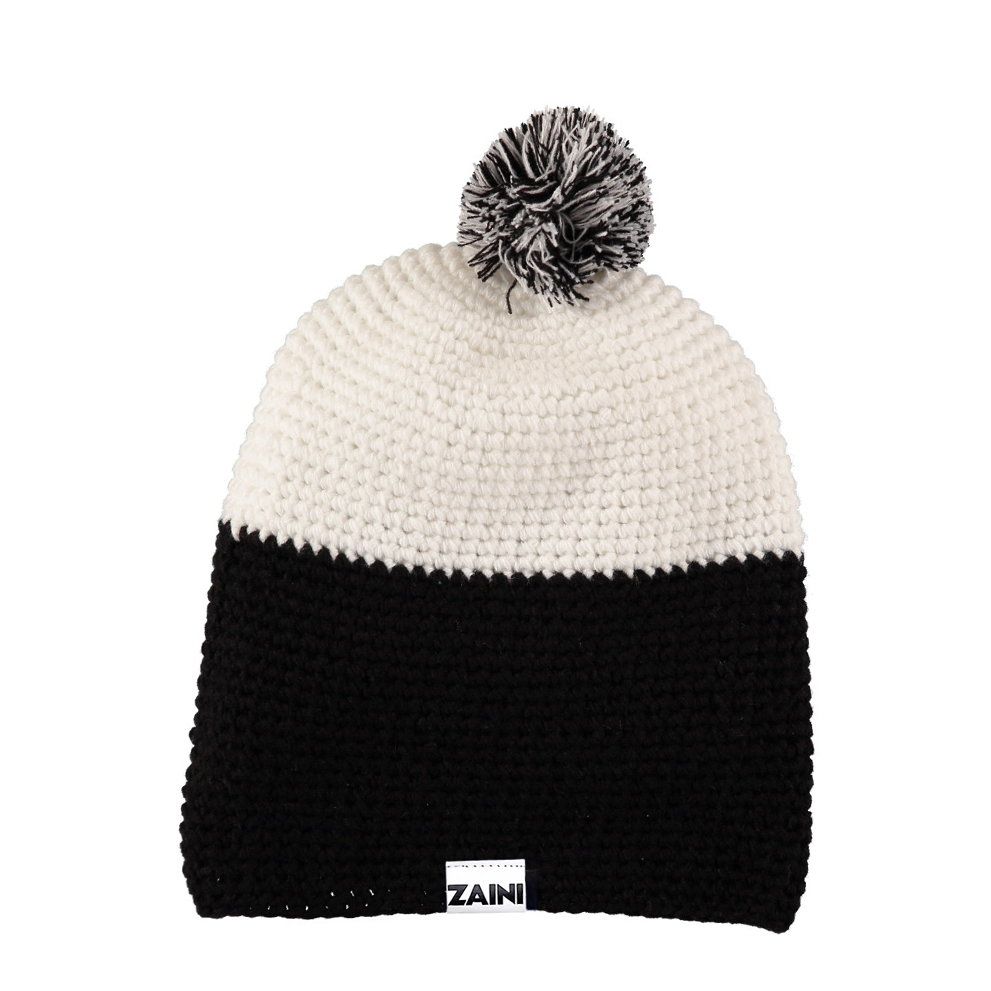 A black and white bobble hat with a pom-pom on the top, made from acrylic yarn, with a label showing the brand name 'ZAINI'.