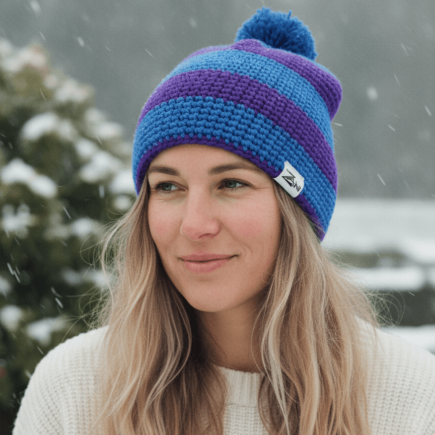 Woman wearing a blue and purple striped beanie in a snowy outdoor setting