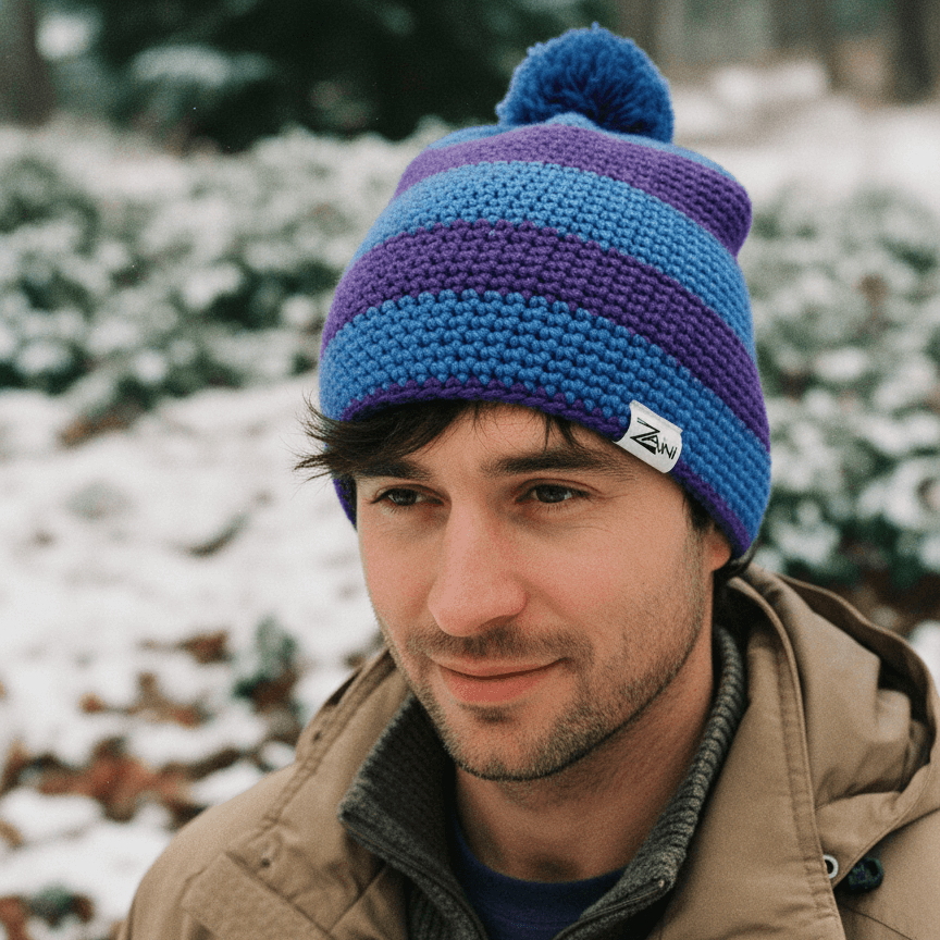Man wearing a blue and purple striped beanie in a snowy outdoor setting