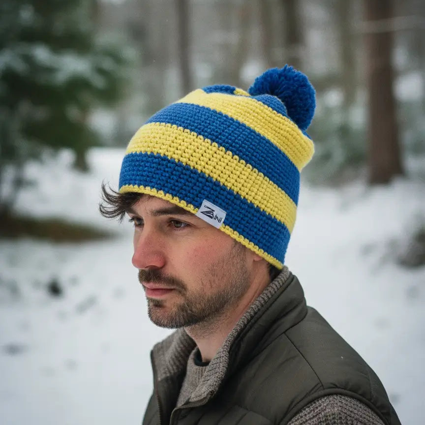 Man wearing a Zaini brand blue and yellow striped beanie bobble hat
