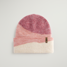 Color-blocked knit beanie with pink, purple, and white sections on a light gray background