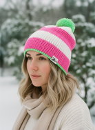 Woman wearing a colorful knit beanie in a snowy forest