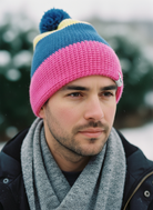 Man wearing a colorful knit beanie and scarf outdoors
