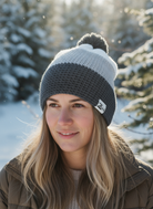 Woman wearing a two-tone beanie with a logo in a snowy outdoor setting