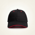 Black cap with red interior and rim on a beige background