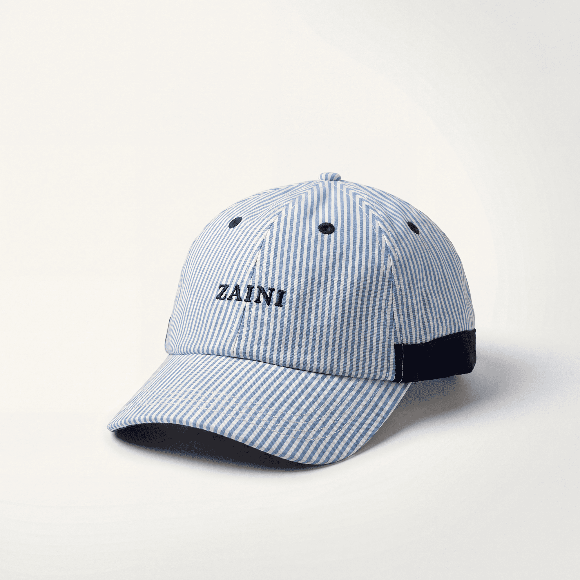 Blue and white striped cap with 'ZAINI' logo on a light gray background