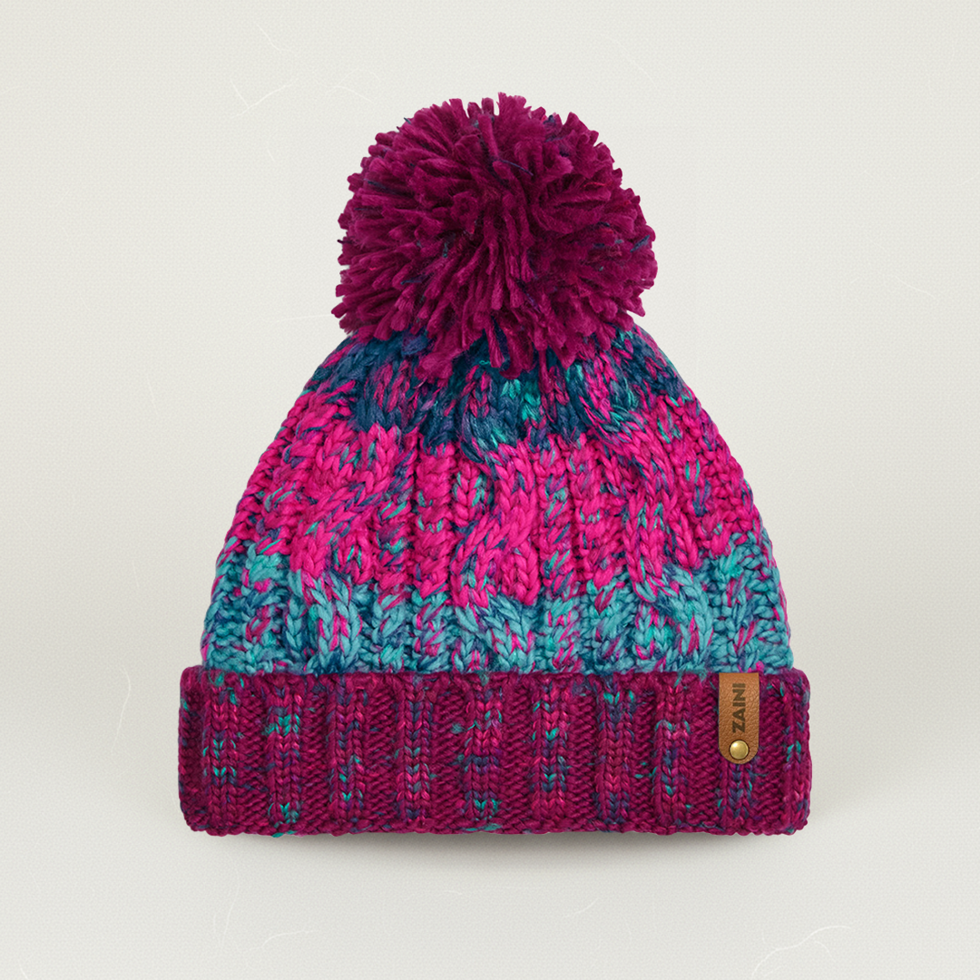 Knitted beanie with a pom-pom on a light gray background