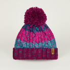 Knitted beanie with a pom-pom on a light gray background