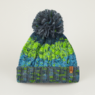 Knitted beanie with green and blue pattern and gray pom-pom on a light gray background