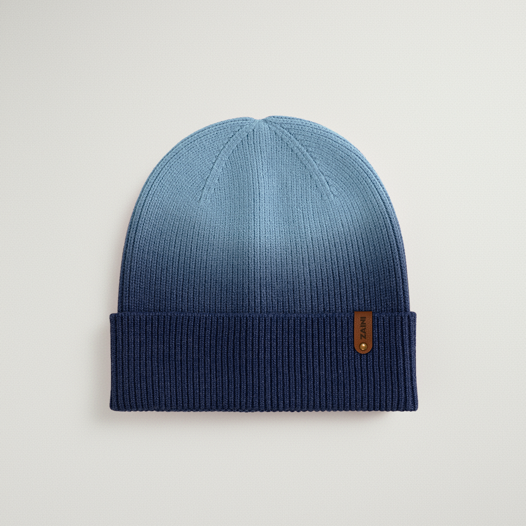 Blue knit beanie with a brand logo on a light gray background
