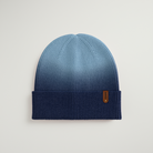 Blue knit beanie with a brand logo on a light gray background