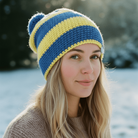 Woman wearing a blue and yellow striped knit hat in a snowy outdoor setting