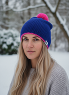 Woman wearing a blue and pink beanie in a snowy outdoor setting
